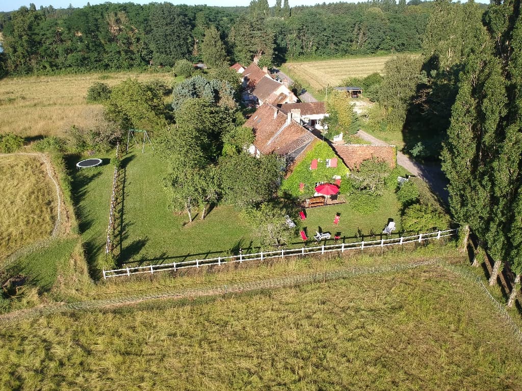 Aerial view of the walled garden with the trampoline, the house and the surrounding fields