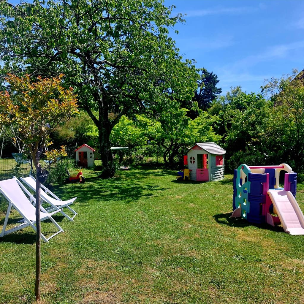 Large garden with sun loungers, children's playhouses and a slide under the trees