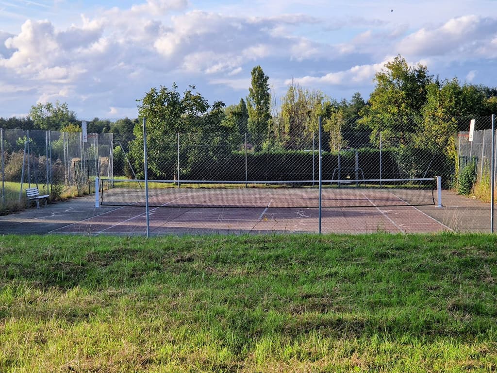 Private tennis court surrounded by poplar trees